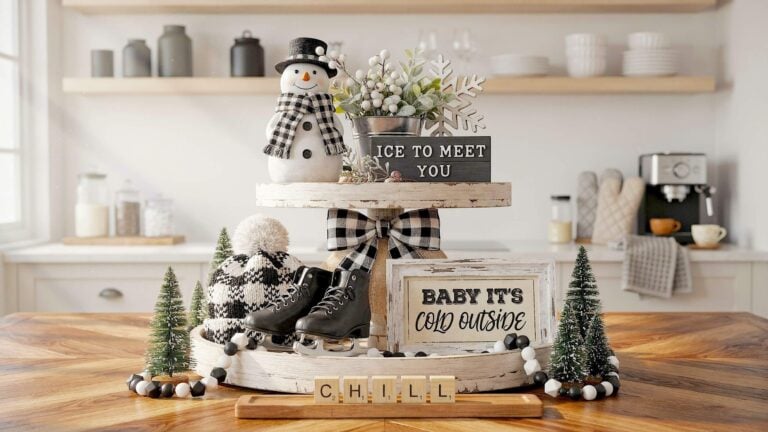 A distressed white wooden tiered tray on a warm oak table features miniature black ice skates near a snowman wearing a checkered scarf for winter tiered tray ideas.