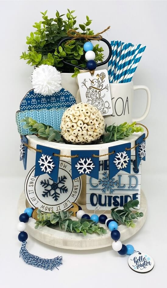 A mix of greenery, striped straws, and bold blues makes this a bright and cheerful setup for Winter Tiered Tray Ideas.