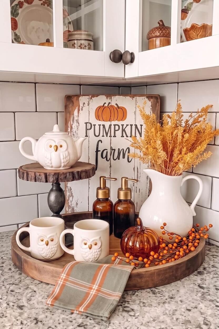 White ceramic owl mugs and a matching teapot are placed on a round wooden tray next to a rustic pumpkin farm sign, offering rustic autumn coffee nook inspiration.
